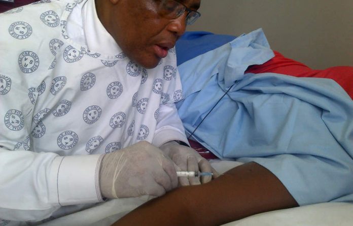 Health Minister Aaron Motsoaledi administers a contraceptive injection.