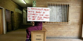 A health worker hides their face while holding a placard detailing shortcomings at Chris Hani Baragwanath Hospital in 2014. This year