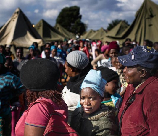 People queue in makeshift camps following past threats of xenophobic attacks in South Africa. Today