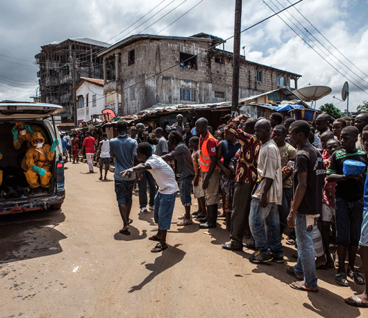 Volunteers arrive to pick up bodies of people who died of Ebola in the 2014-2015 outbreak.