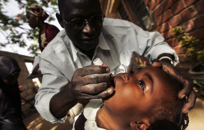 A Nigerian schoolgirl is vaccinated against polio during a mass nationwide polio inoculation.