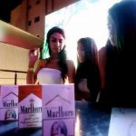 Young girls pose with boxes of Marlboro cigarettes.