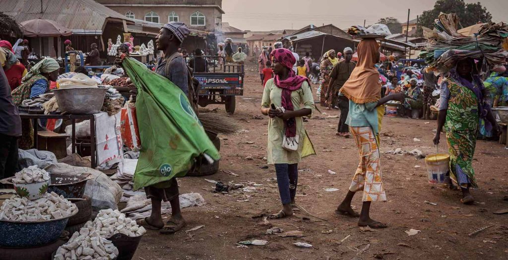 Women sell cowpea at a bustling grain and vegetable market in Tamale