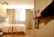 Person Holding on Door Lever Inside Hotel Room